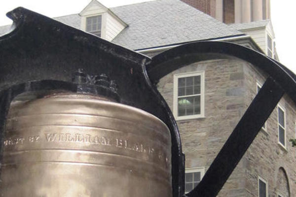 Photo of bell with Old Main in the backgroun