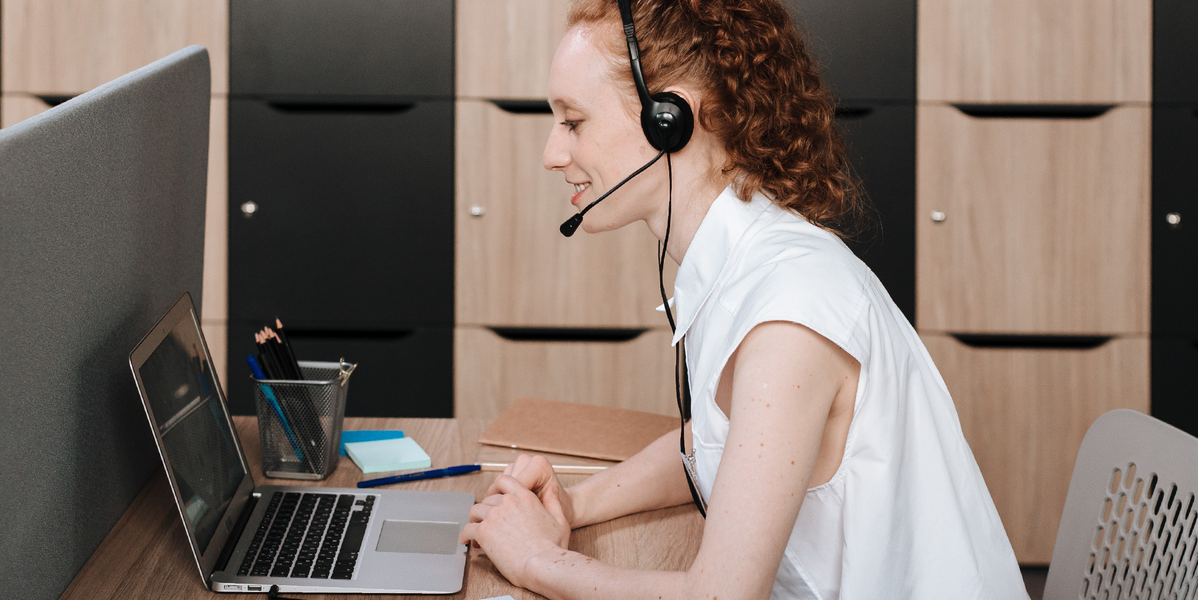Woman with headset looking at a laptop